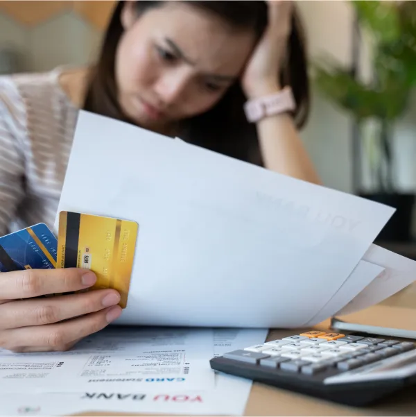 Femme tenant une carte de crédit et des documents pour un prêt avec un mauvais crédit.