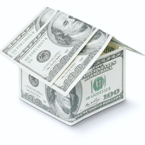 Maison construite en billets de banque sur fond blanc, symbolisant la richesse et les prêts en ligne.