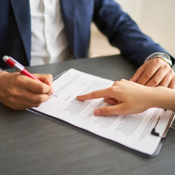 Un homme et une femme signant un contrat sur un bureau. Prêt rapide.