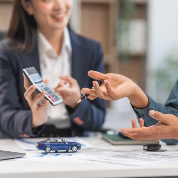 Une femme tenant une clé de voiture et un homme tenant une calculatrice. Prêt rapide.